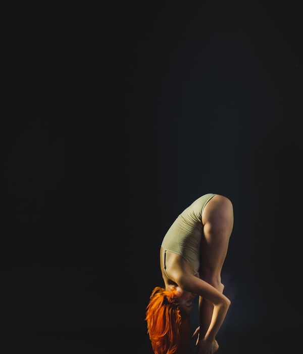 Woman performing a deep forward bend, illustrating flexibility.
